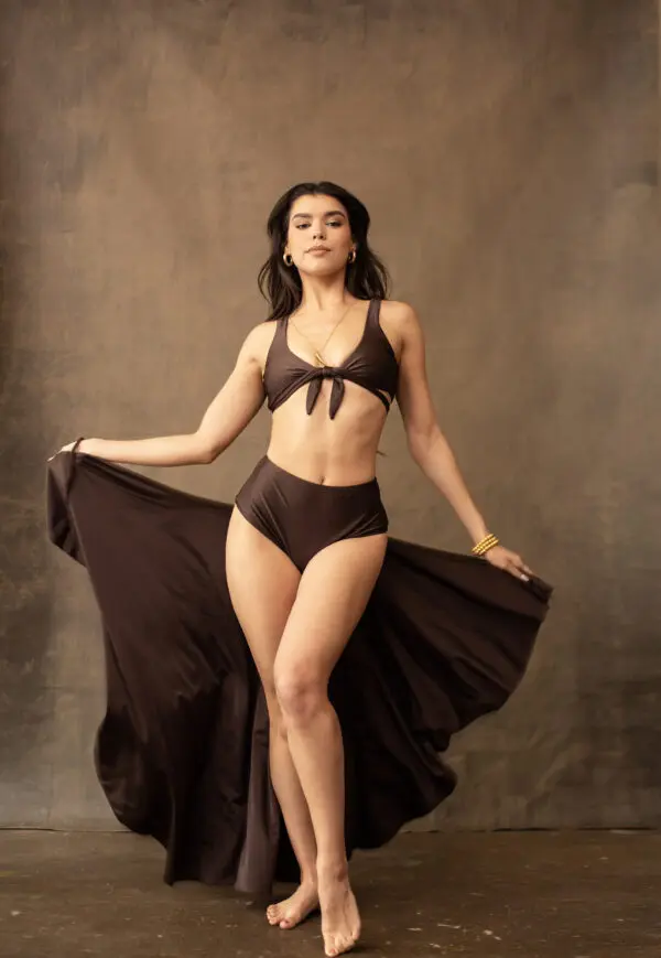 A woman in black bikini and flowing skirt.